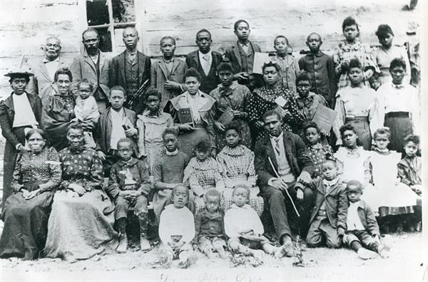 A large group of settlers pose for a photo